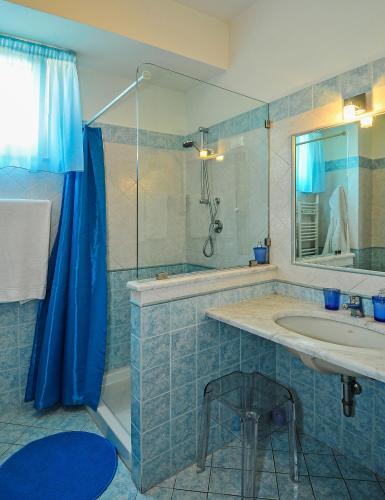 a bathroom with a sink and a shower with a mirror at B&B Ai Cipressi in Lucca