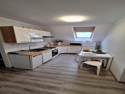 a small kitchen with white cabinets and a table at Apartment in Stepnica near Szczecin Lagoon in Stepnica