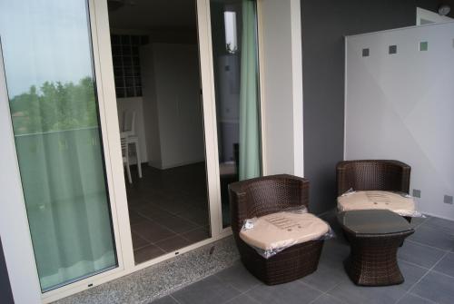 two wicker chairs with ottomans sitting in front of a mirror at Guest House Residence Malpensa in Case Nuove
