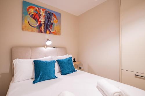 a bedroom with a white bed with blue pillows at Seanáras Beag in Galway