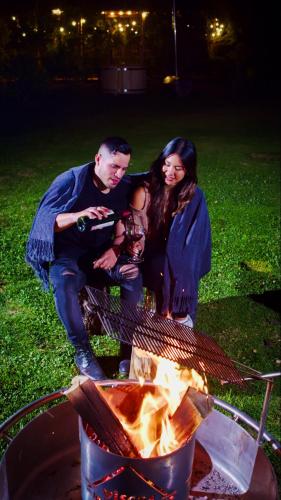 a man and a woman sitting next to a grill at Viscas Lodge in Carhuaz