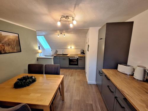 een keuken en eetkamer met een houten tafel in een kamer bij Ferienwohnung Krähling in Schmallenberg