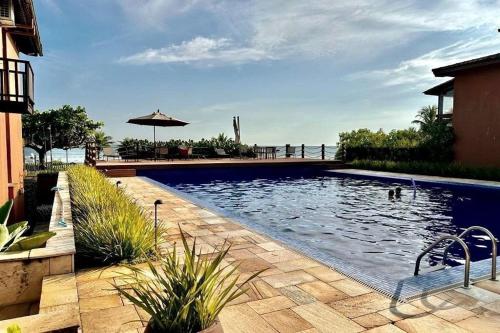 a large swimming pool in a yard with a house at Praia da Baleia | Frente ao Mar c/ Quiosque in São Sebastião