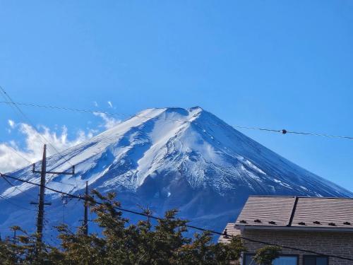 a snow covered mountain in front of a blue sky at RISA INN Fuji in Fujiyoshida