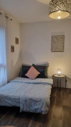 une chambre avec un lit avec une couverture bleue dans l'établissement Nid Paisible bord du Lac entre Disney et Paris, à Torcy