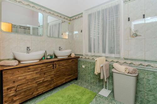 a bathroom with two sinks and a tub at House Lucic in Zaton
