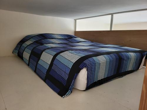 a bedroom with a bed with a blue comforter at Appartement Joeuf, 2 chambre cosy et lumineux in Joeuf