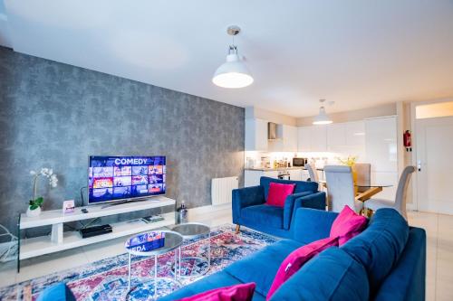 ゴールウェイにあるLuxury Apt with Parkingの青いソファとテレビのあるリビングルーム