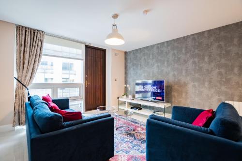 ゴールウェイにあるLuxury Apt with Parkingの青いソファ2脚とテレビのあるリビングルーム