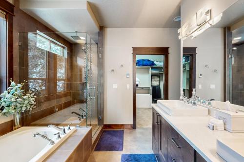 een badkamer met twee wastafels, een bad en een douche bij Peaceful Peaks Hideout in McCall