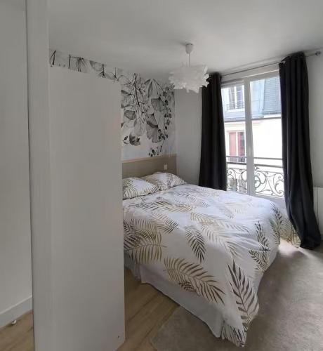 une chambre avec un lit avec une grande fenêtre dans l'établissement Appartement cosy - Saint Louis Paris 10, à Paris