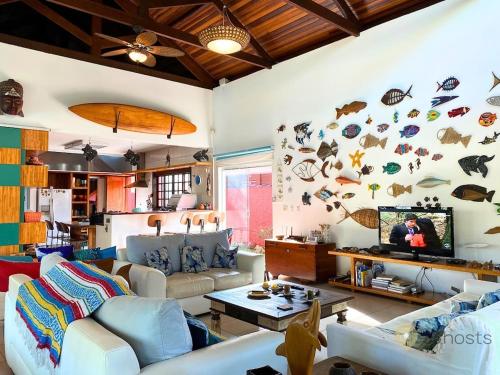 ein Wohnzimmer mit Sofa und Fernseher in der Unterkunft Casa Paraiso Praiano 2 minutos da praia · Barra do Una | Paraíso praiano a 120m da praia in São Sebastião