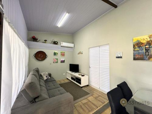 Una sala de estar con un sofá y un televisor. en Chateau Gil em Juquehy, en São Sebastião