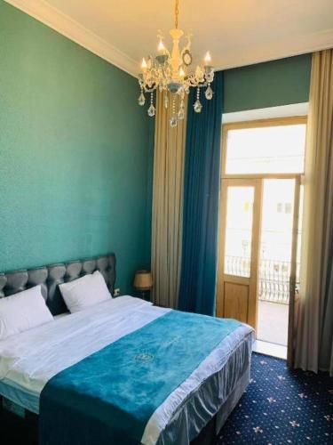 a bedroom with a large bed and a chandelier at Belona Hotel in Kutaisi
