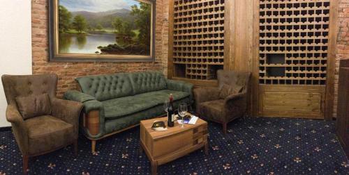 a living room with a green couch and two chairs at Belona Hotel in Kutaisi