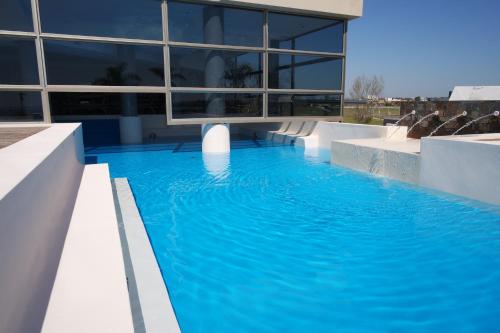 a large building with a large blue swimming pool at Arena Resort in Federación