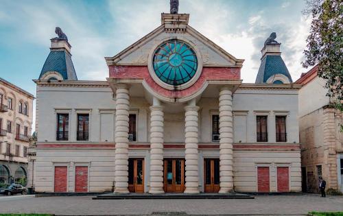a building with a clock on the top of it at Belona Hotel in Kutaisi