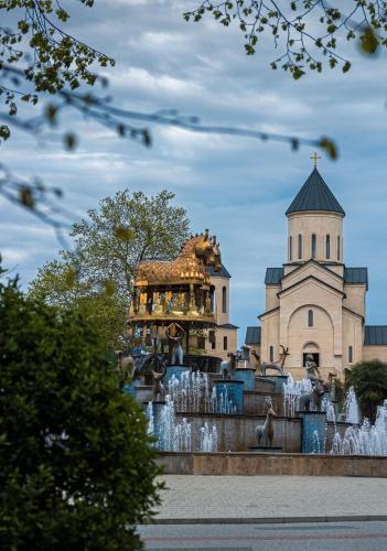 a fountain in front of a building with a horse statue at Belona Hotel in Kutaisi