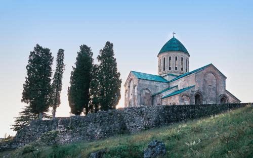 an old church with a tower on top of a hill at Belona Hotel in Kutaisi