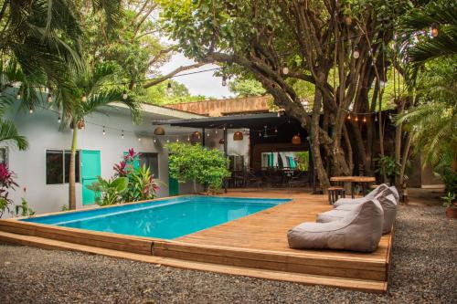 a pool in a backyard with a wooden deck and a poolitures at Refugio Surf Lodge in Tamarindo