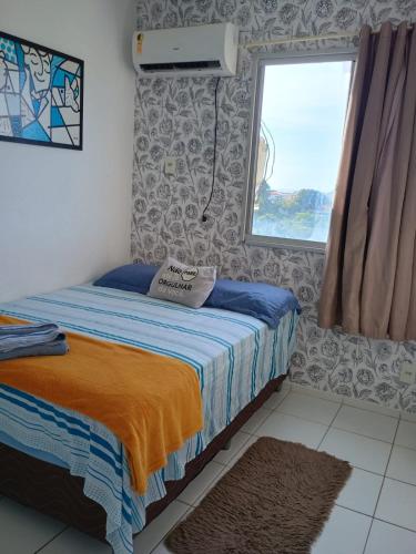a small bedroom with a bed and a window at Bela Casa PX as praias in São Luís