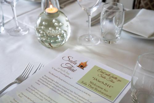 a table with a white table cloth with wine glasses at Kells Bay House and Gardens in Kells