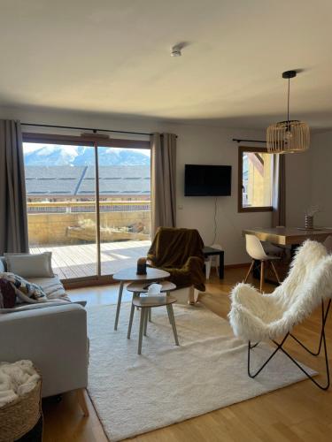 a living room with a couch and a table at Bel appartement 2 chambres - tout équipé - Terrasse sud- Bolquere Station de ski Font Romeu Pyrénées 2000 in Bolquere Pyrenees 2000