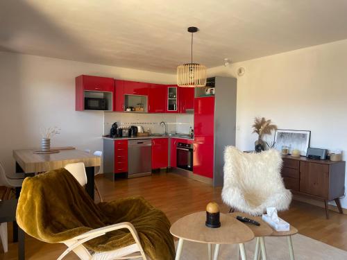a living room with red cabinets and a kitchen at Bel appartement 2 chambres - tout équipé - Terrasse sud- Bolquere Station de ski Font Romeu Pyrénées 2000 in Bolquere Pyrenees 2000