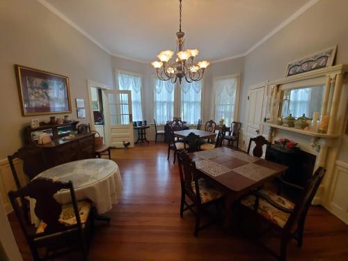a dining room with a table and chairs and a chandelier at The Old Buggy Inn in Carthage