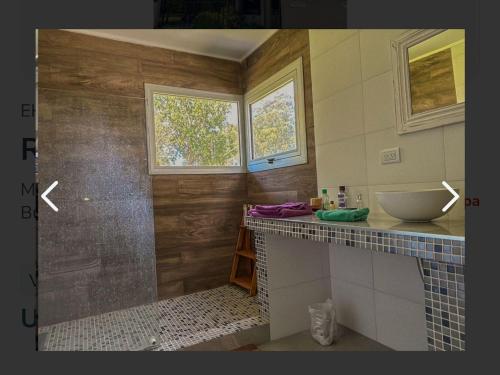 a bathroom with a counter with a sink and a window at Casa mar chiquita in Mar del Plata