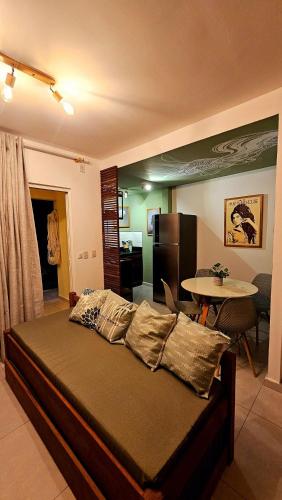 a bedroom with a bed and a kitchen and a table at Solar Águas Pipa Prime in Pipa