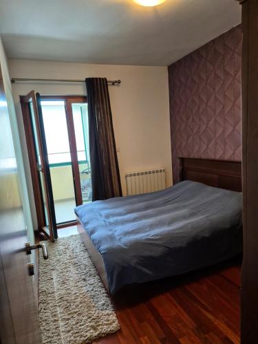 ein Schlafzimmer mit einem Bett und einer Glasschiebetür in der Unterkunft Infinity Durmitor in Žabljak