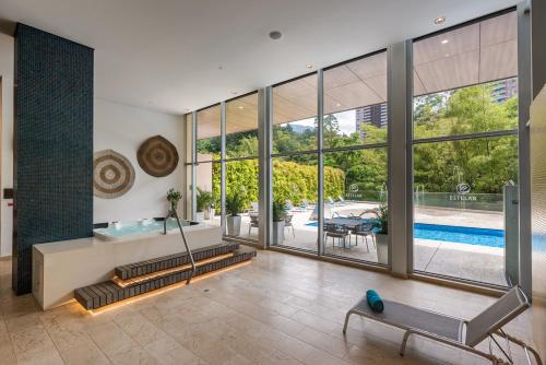 una sala de estar vacía con una piscina vista a través de las ventanas en Estelar La Torre Suites, en Medellín