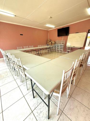 a conference room with tables and chairs and a projection screen at Senate Way Guest House in Kimberley