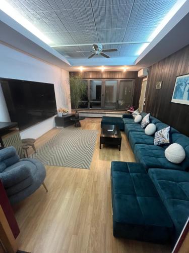 ein Wohnzimmer mit blauen Sofas und einem Flachbild-TV in der Unterkunft Villa Pantana Beach in Trogir