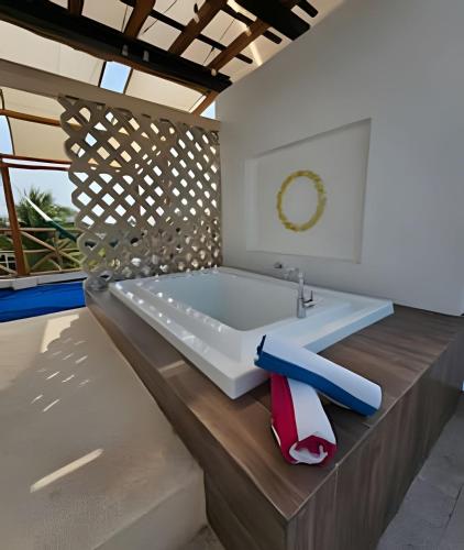 a bathroom with a bath tub with a sink at Villa Tortugas in Chicxulub