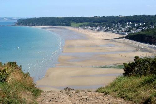 a view of a beach with the ocean and houses at Appartement Port du Légué T2 in Plérin
