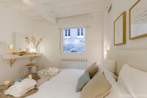 a white bedroom with a bed and a window at Center Pamplona Apartment UAT00537 in Pamplona