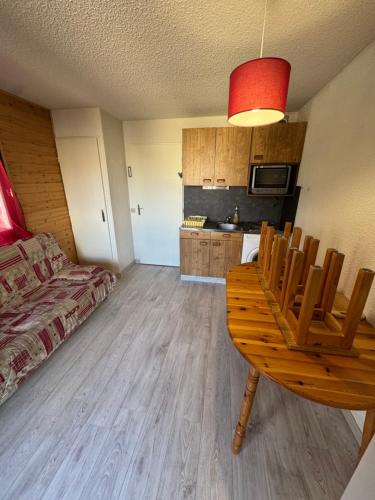 Cette chambre comprend un lit, une table et une cuisine. dans l'établissement Cocon Vercors, Centre Village, à Villard-de-Lans
