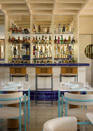 a restaurant with two tables and chairs and shelves with jars at Ace Hotel & Swim Club Athens in Athens