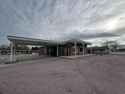 an empty gas station with a cloudy sky at Siesta Motel in Mitchell