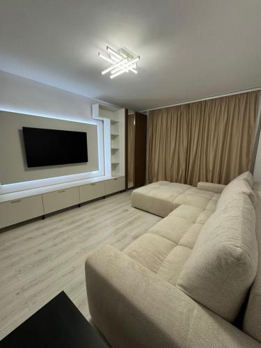 Una sala de estar con un sofá y un televisor de pantalla plana. en Central Apartments, en Craiova