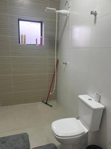 a bathroom with a white toilet and a window at Chácara encantadora Ibiuna in Ibiúna