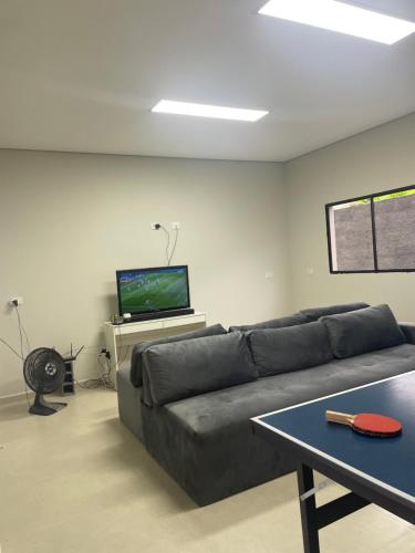 a living room with a couch and a tv at Chácara encantadora Ibiuna in Ibiúna