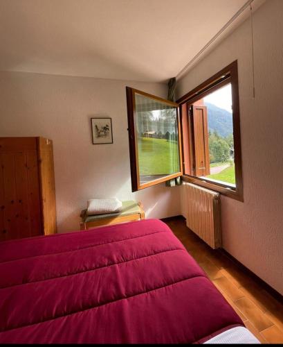 a bedroom with a bed and a large window at Ski-Garden in Mezzana