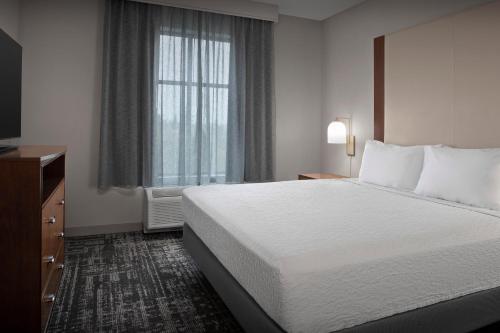 a hotel room with a bed and a window at Homewood Suites by Hilton Seattle/Lynnwood in Lynnwood