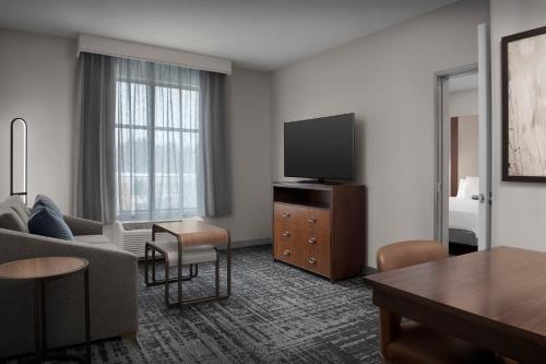 a living room with a couch and a tv at Homewood Suites by Hilton Seattle/Lynnwood in Lynnwood