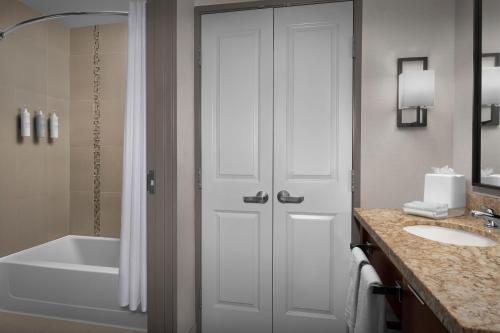 a bathroom with a tub and a shower and a sink at Homewood Suites by Hilton Seattle/Lynnwood in Lynnwood
