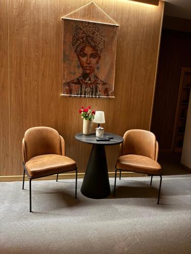 a room with two chairs and a table and a painting at R34 Boutique Guest House in Veliko Tŭrnovo