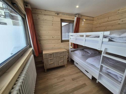 une chambre avec deux lits superposés et une fenêtre dans l'établissement Résidence Pontet B - Appartement rénové · Wifi · Balcon · Pied pistes MAE-1751, à Tignes